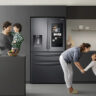 A family in the kitchen with the Samsung Family Hub fridge behind them.